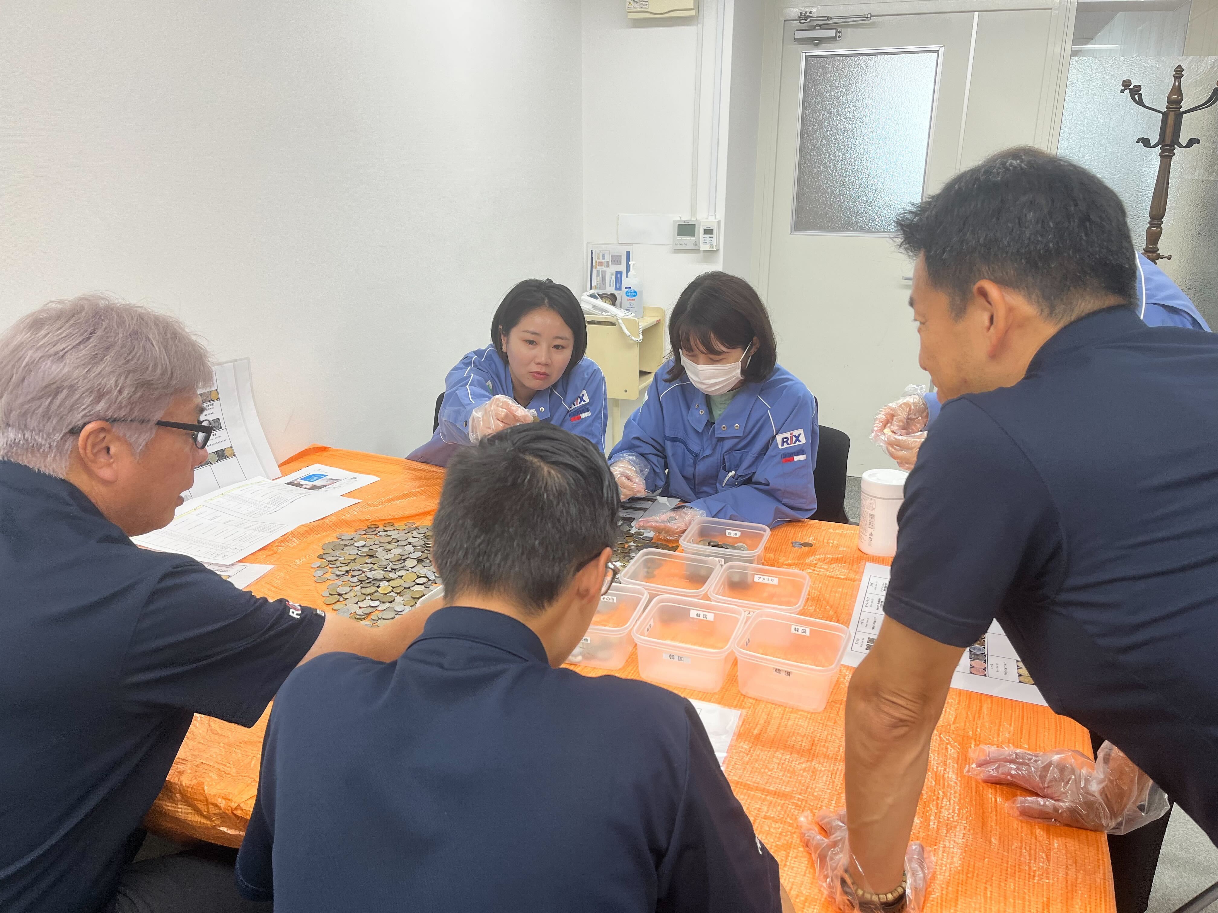 外貨コインを仕分ける参加者の皆さん